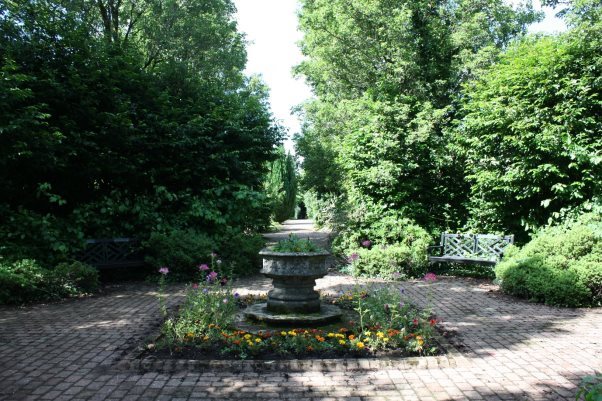 A stone fountain surrounded by treesDescription automatically generated with low confidence
