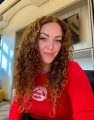 A person with long curly hair taking a selfieDescription automatically generated with medium confidence