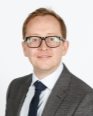 A person in a suit and tieDescription automatically generated with medium confidence