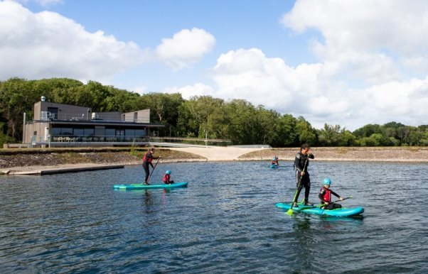 People on kayaks on a lakeDescription automatically generated