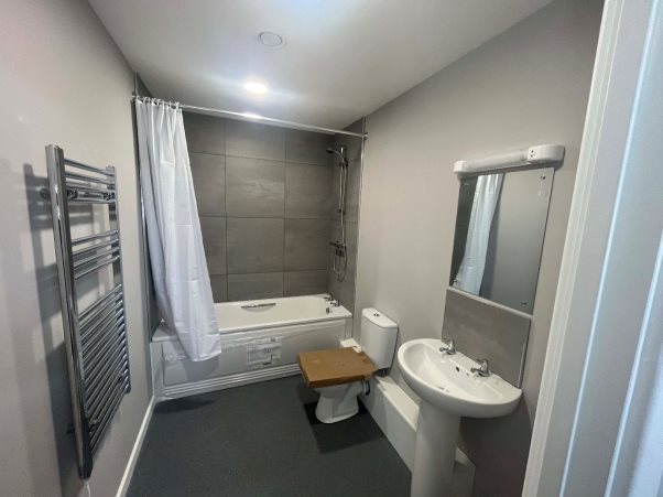 A bathroom with a toilet and sinkDescription automatically generated