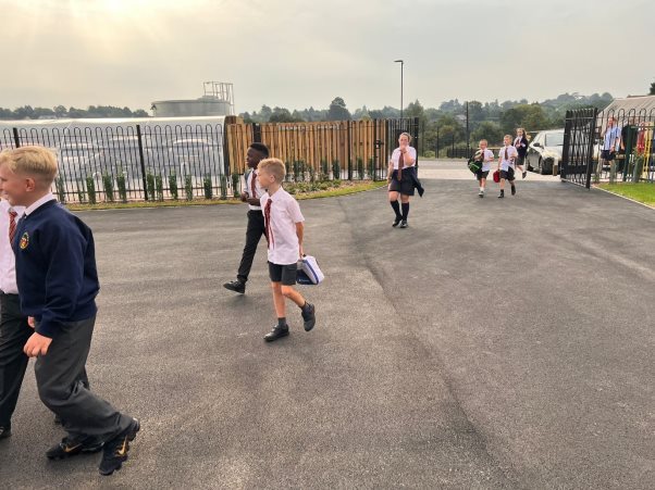 A group of people walking on a roadDescription automatically generated