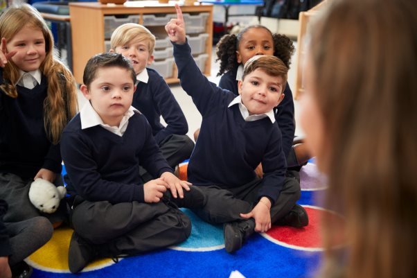 A group of children sitting on the floorDescription automatically generated