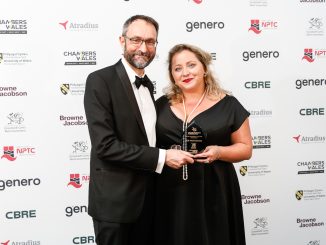 A man and a woman standing in front of a wards background