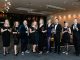 A group of people standing with awards