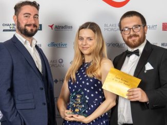 Three people standing at an awards ceremony