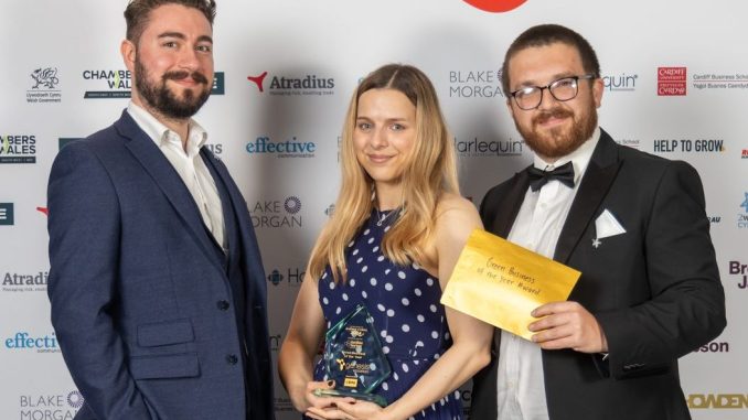 Three people standing at an awards ceremony