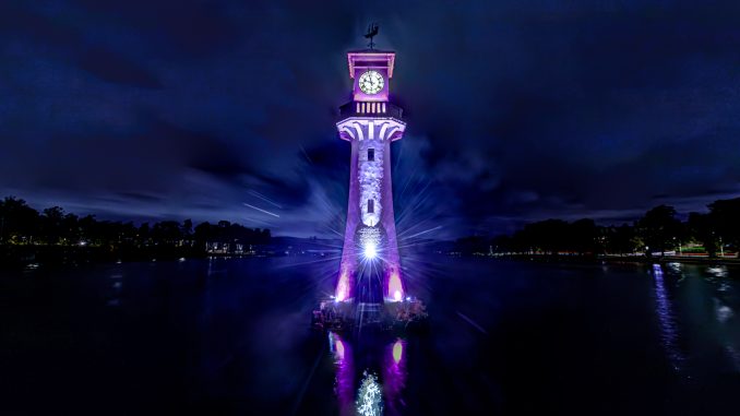 A photo taken at night of Roath Park's lighthouse lit up in City Hospice purple for the Light Up A Life appeal.