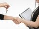 A real estate transaction with a handshake and key exchange, highlighting a home insurance document.