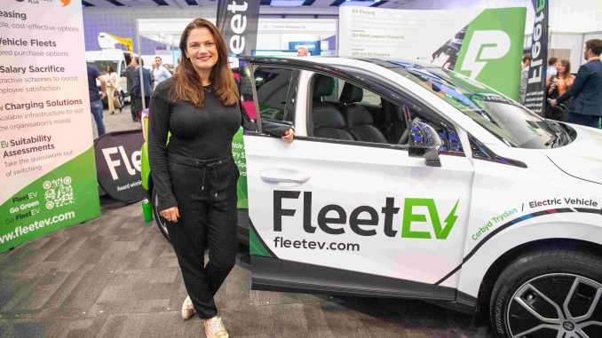 Hannah Williams stood in front of a branded FleetEV car.