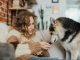 Woman relaxing on couch with a Siberian Husky, creating a cozy and warm atmosphere.
