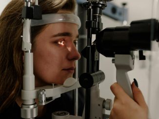 A woman undergoing an eye examination using a slit lamp in a modern clinic setting.