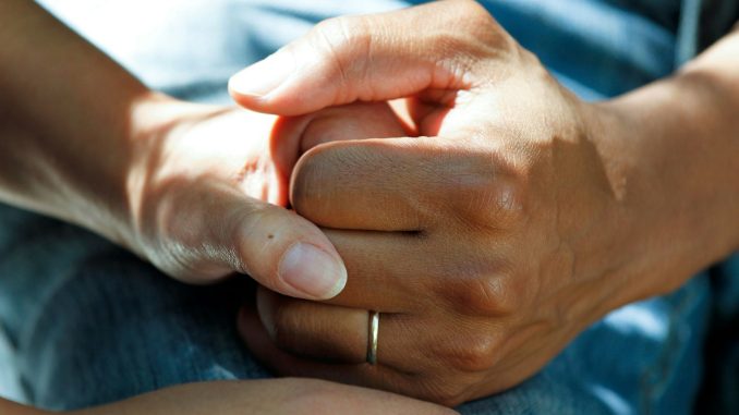 person wearing gold wedding band