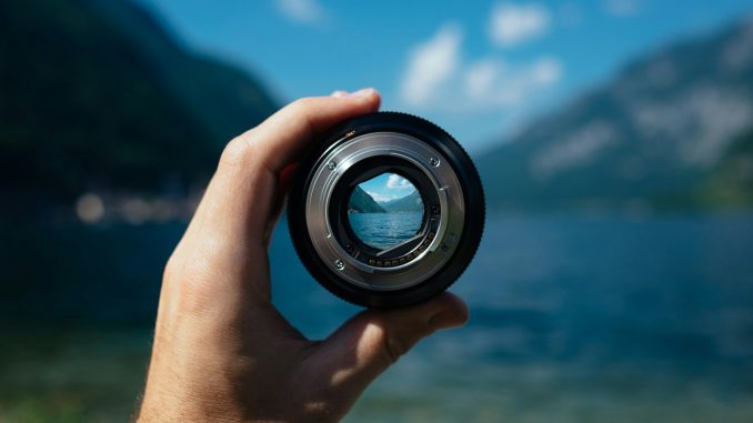 person holding camera lens
