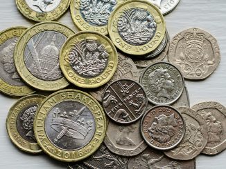 a pile of british coins sitting on top of a table