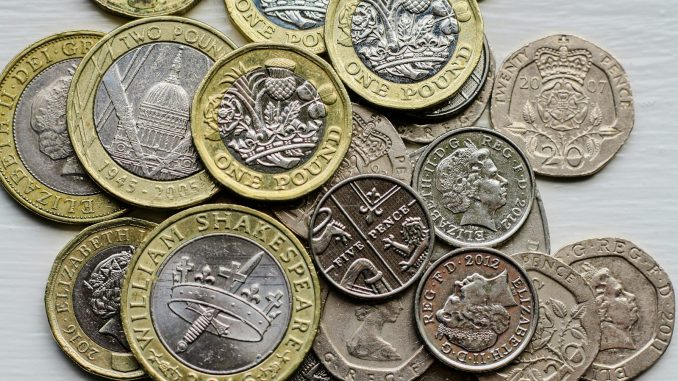 a pile of british coins sitting on top of a table