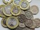 a pile of british coins sitting on top of a table
