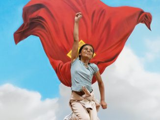 A child jumping in a Superman pose in front of the mural in The Red Dragon Centre