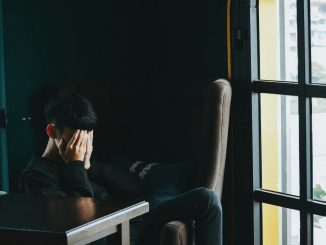 man in black jacket sitting on chair