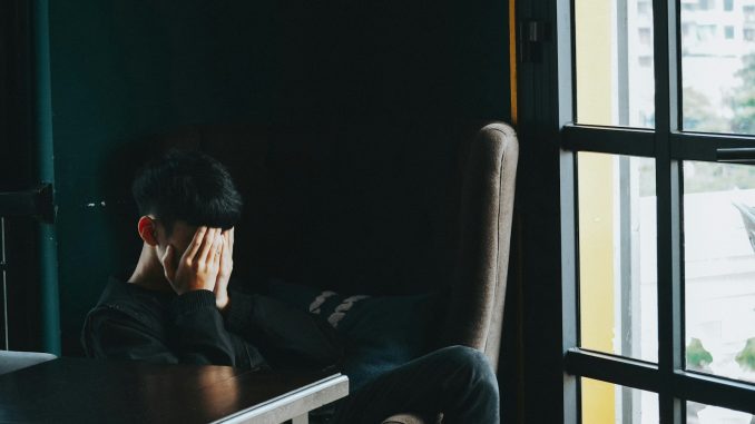 man in black jacket sitting on chair