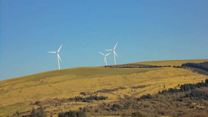 Scenic view of wind turbines on hills in Cymmer, Wales, showcasing renewable energy in a natural setting.
