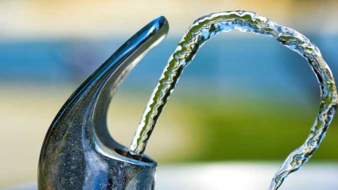 silver faucet with water droplets