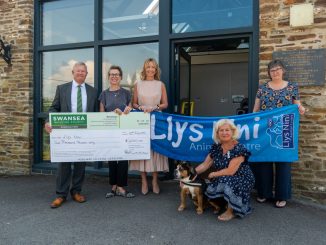 Alun Williams, CEO of Swansea Building Society, hands cheque for £2,000 to the team at Llys Nini.